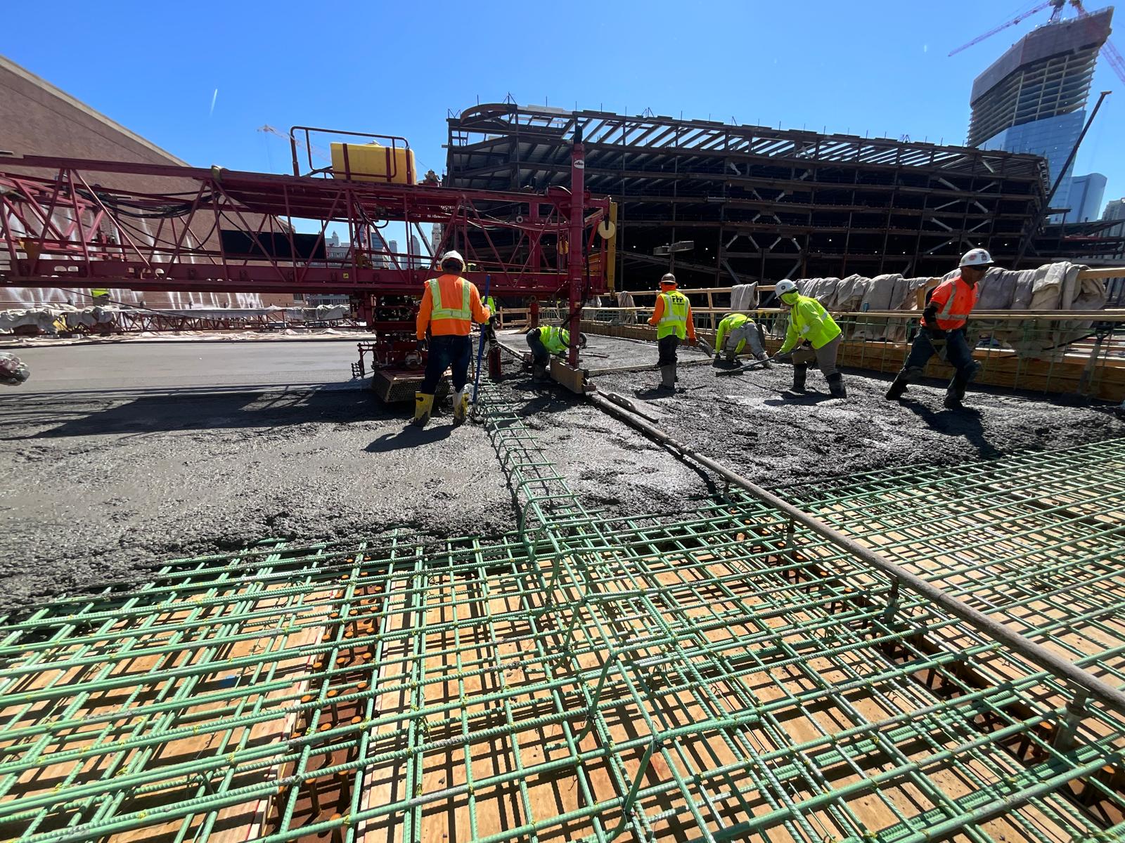 CHI-UG team placing concrete over reinforcement on a civil works site.