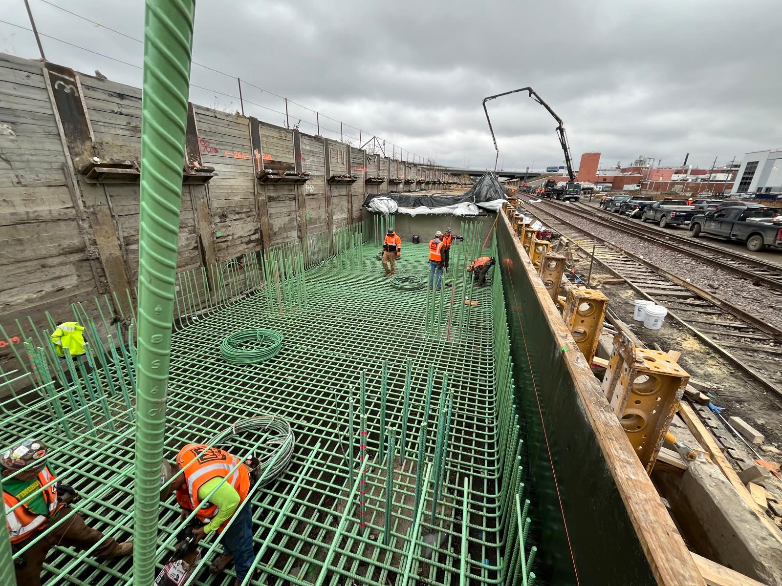 CHI-UG engineers supervising a deep excavation with reinforcement cage and sheet piling.