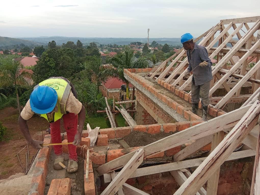 CHI-UG workers carrying out roofing and structural brickwork on a residential building site.