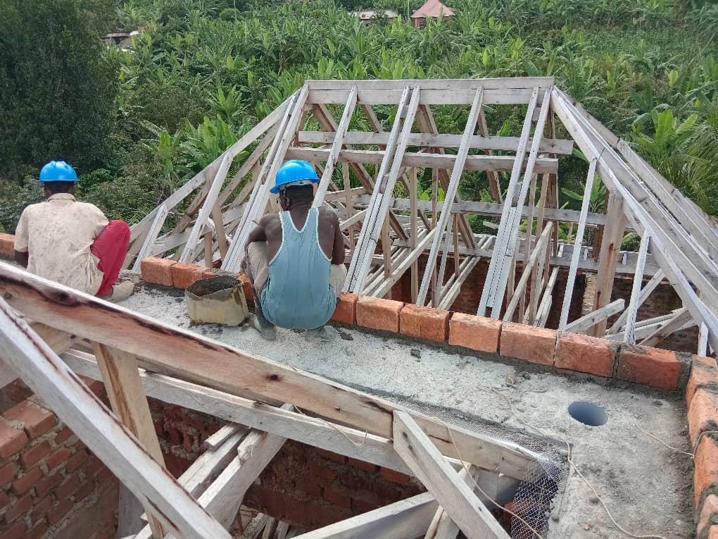 Timber roof truss framing over brick walls on a residential project in Uganda.